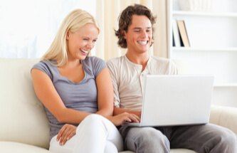 a couple having fun playing on their computer