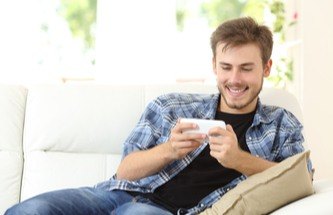 Gamer reclined in comfortable chair playing on his phone