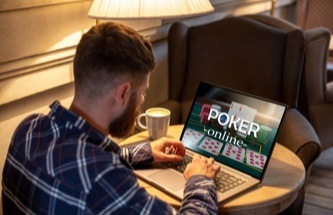 player relaxing with warm drink playing blackjack on his laptop