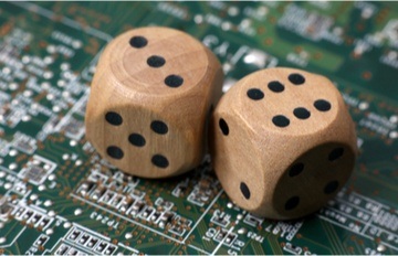 two brown die with black dots set on a background of a computer board with many chips indicating a random number generator 