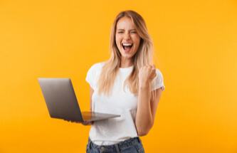 happy blonde woman doing a thumbs up after winning at Everygame Casino on her laptop