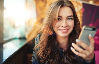 happy woman playing Everygame Casino games on her phone.