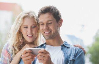 couple having fun playing at Everygame Casino on the phone