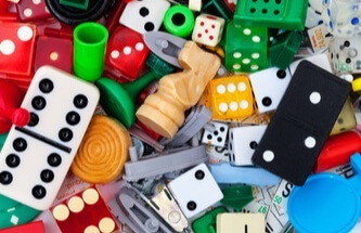a collection of miscellaneous game pieces: dice, chess pieces, lego, dominoes, checkers