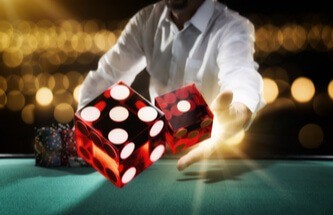 man throwing dice at a craps table with chips
