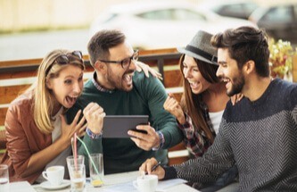 four friends gaming together on a tablet having fun