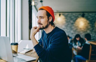 a guy thinking deeply about something on his laptop