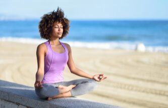 woman meditating on the beach