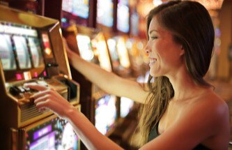 a woman playing a slot game at a land-based casino