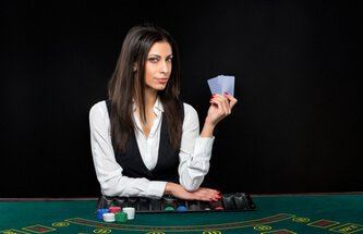 a blackjack dealer holding up two cards