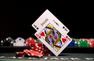 blackjack table with chips and a queen of hearts and ace of spades