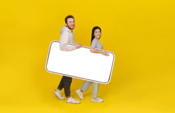 young man and woman carrying symbolically large smartphone as they go on vacation so they can play casino games online