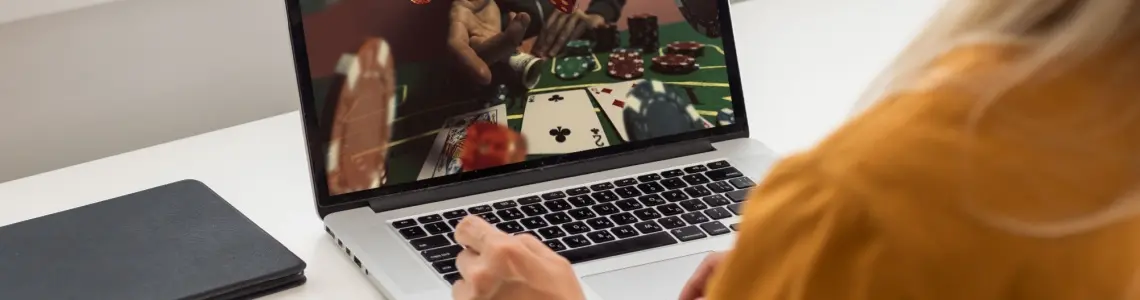 attractive woman with long blond hair seen from the side playing at an online casino and smiling as she enjoys the gaming