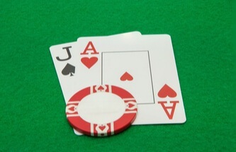 poker table showing Jack and Ace cards with casino chips on the table