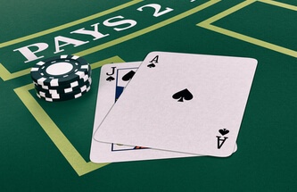 a true blackjack with an ace and a jack of spades. The table is green felt with light green spaces for bets.