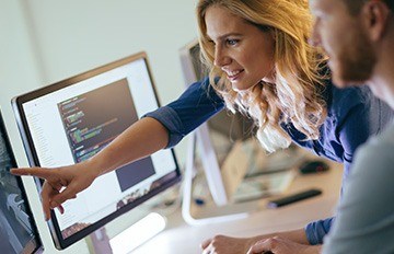 a young man and young woman working as a team as they develop computer technology