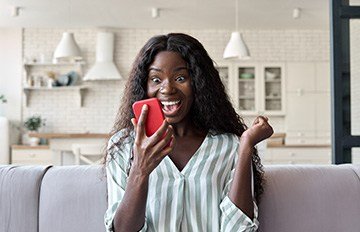 young woman happily winning playing a casino game on her smartphone