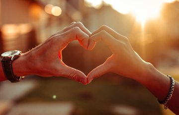 a photo of a man and a woman holding their hands together to form a heart