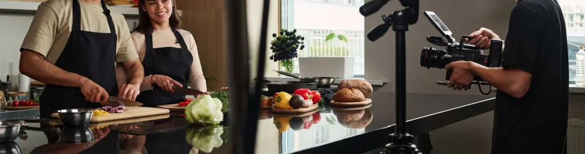 a smiling young couple making a cooking show together that people will watch for entertainment