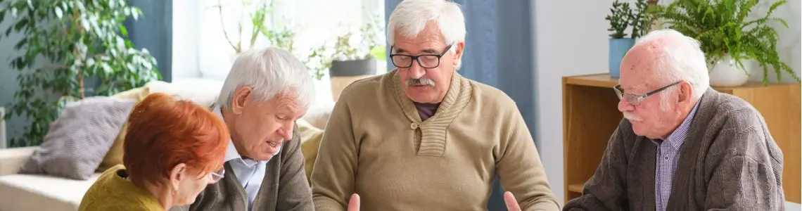 four older people enjoying playing a table game