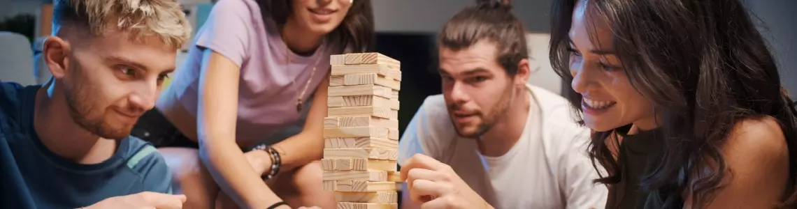 a small group of friends playing Jenga