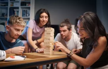 a small group of friends playing Jenga