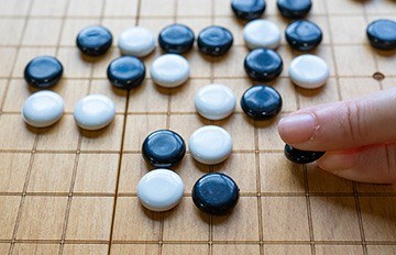 man in a suit holding two pieces of a puzzle. each piece says WIN. it shows how strategy helps people succeed.