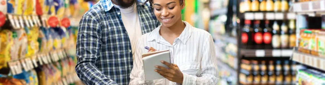 a young couple smiling as they shop together at a supermarket