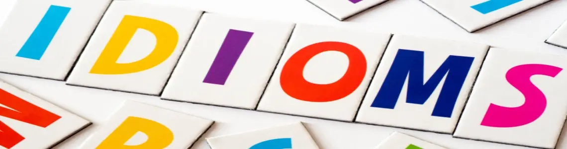 the word idioms spelled out in colorful letters with other colorful letters around