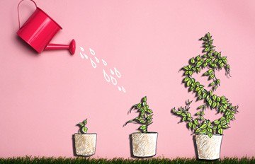 a red watering can watering three plants.  the largest of the plants has grown into the symbol of a dollar