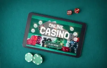 a large tablet with online casino on the screen surrounded by dice and casino chips