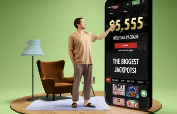a man standing in his living room with an easy chair and a lamp and a giant smartphone towering above him