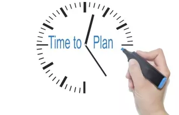 a person using blue highlightre to write in the word "plan" on a clock where the words "time to" already appear