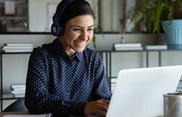 a young woman at her laptop joyfully learning something new.