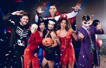 six young adult friends happily celebrating Halloween in costume