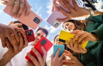 young friends playing online casino games on their phones together