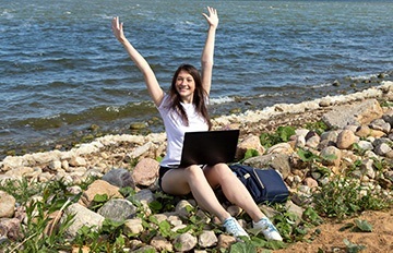 a young woman enjoying mobile gaming while at the ocean