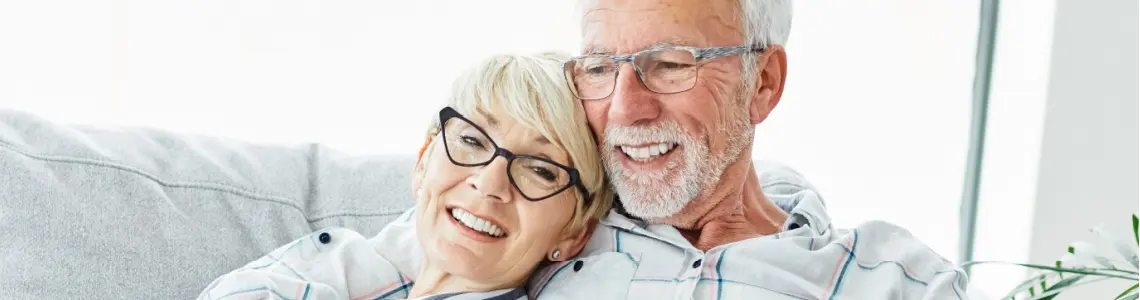 a happy elder couple relaxing together on the sofa