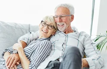 a happy elder couple relaxing together on the sofa