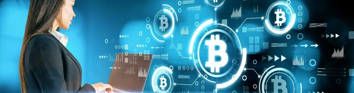 young businesswoman at a laptop board with space age symbols of bitcoin seemingly floating in air