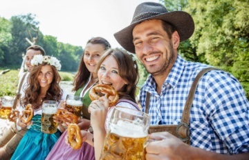 five twentyish friends in traditional garb celebrating Oktoberfest