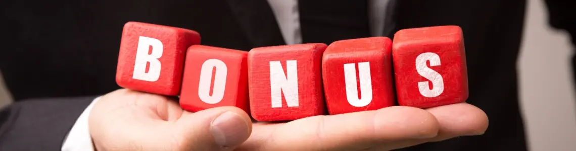 a man wearing a suit and a dark tie holding five red blocks taht spell out the word bonus