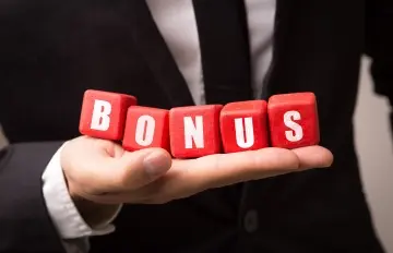 a man wearing a suit and a dark tie holding five red blocks taht spell out the word bonus