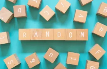 many small wooden blocks strewn about a a blue background with some spelling out the word random