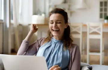 a happy 30-something online casino gamer celebrating a win or a bonus