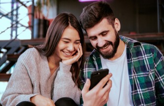 young couple playing and winning on their phones