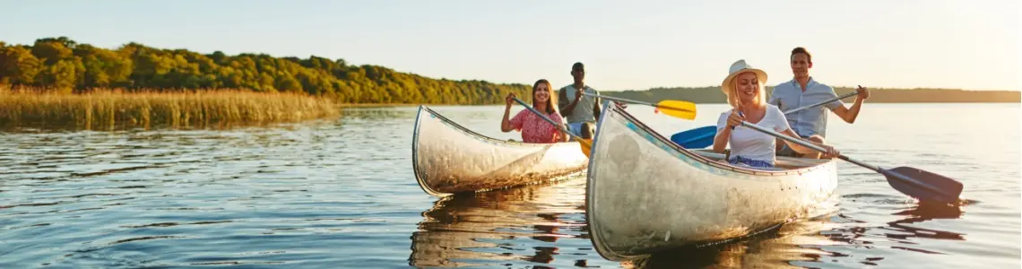 two young couples canoeing on a large lake
