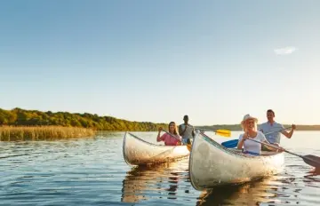 two young couples canoeing on a large lake