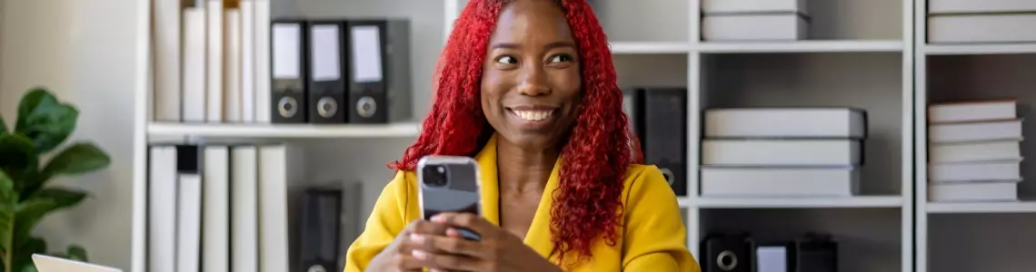 an attractive, smiling African-American businesswoman at work wearing a yellow suit showing how she can make work fun