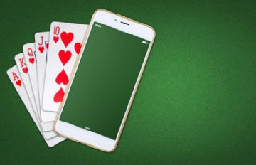 a royal flush in hearts against a green background with a smartphone on the corner of the ten of hearts